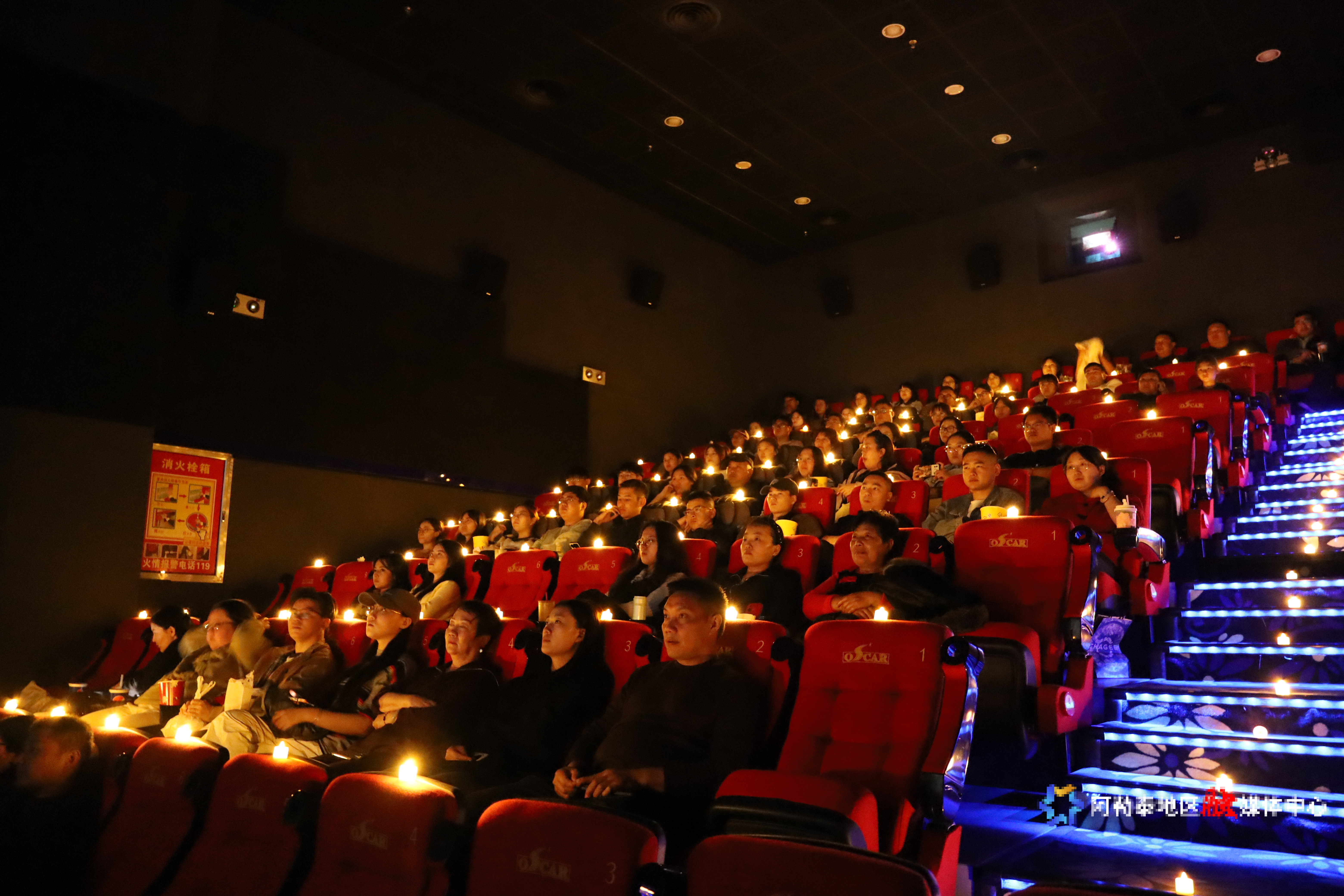 在新强奥斯卡影院设立的微光应史 向光而行 出口有光--纪念场内，观众们正在观看影片。