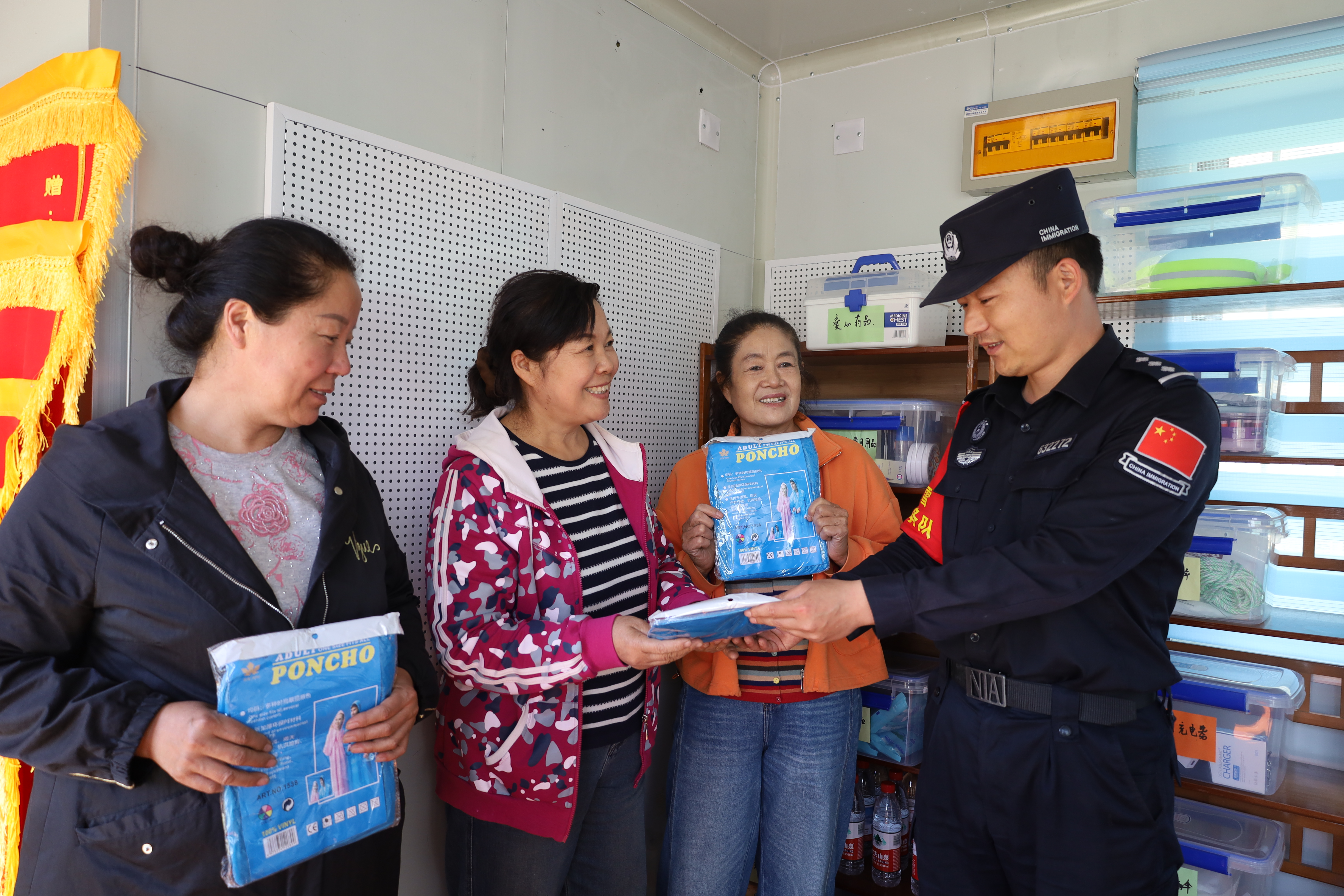 设立于阿克布拉克边境旅游警务驿站的幸福驿站内,游客正领取所需的一次性防雨水衣。